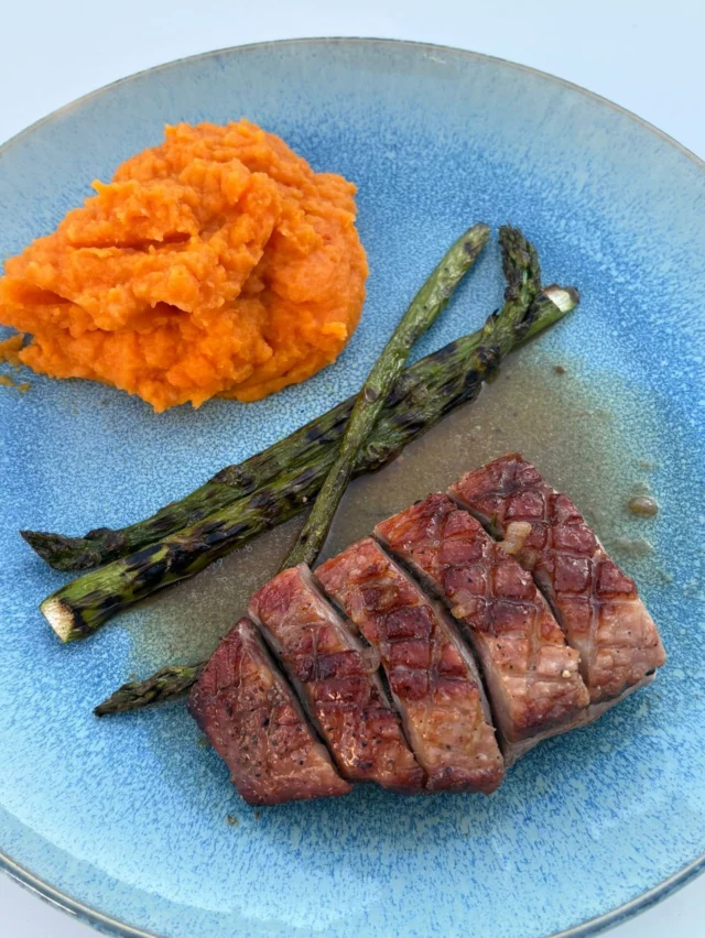 Magret de canard rôti au kamdo, purée de carottes à l’orange et au cumin, asperges vertes, jus corsé