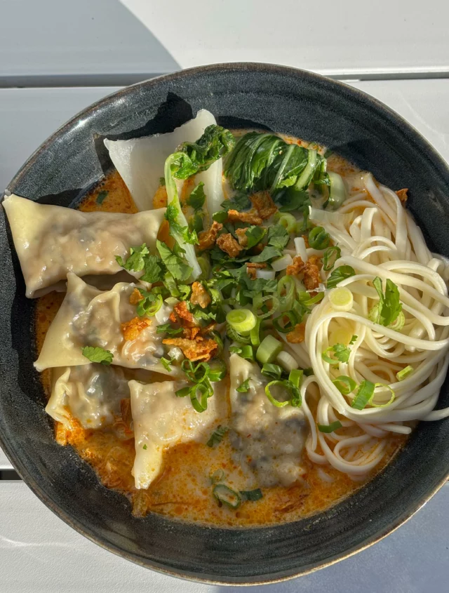 Soupe de wontons et nouilles au curry rouge et lait de coco, pak choi