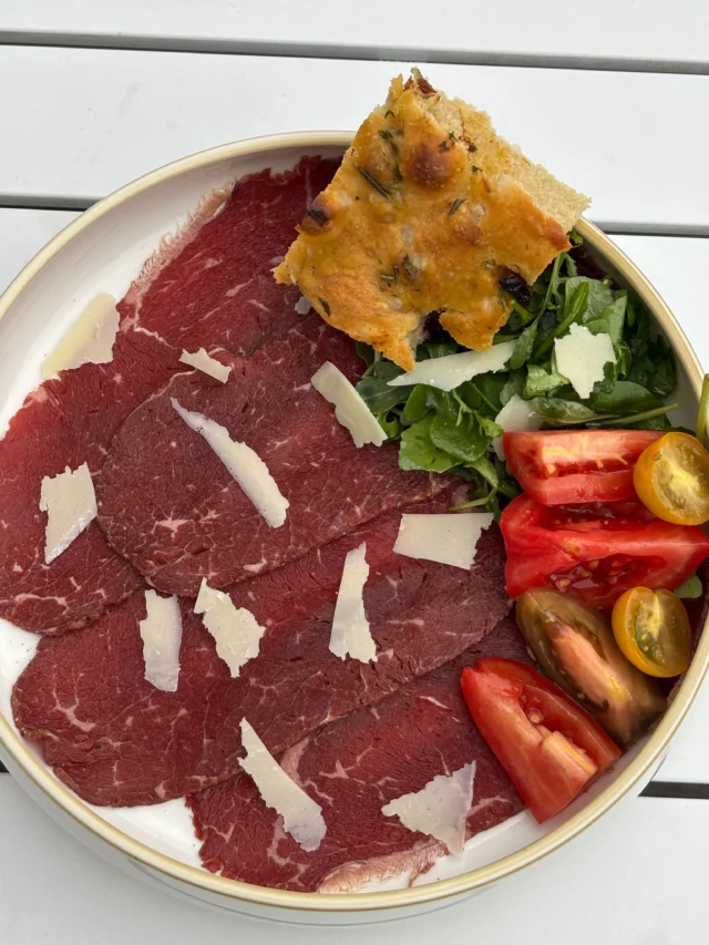 Carpaccio de bœuf Holstein maturé, roquette, parmesan, tomates du moment, focaccia maison